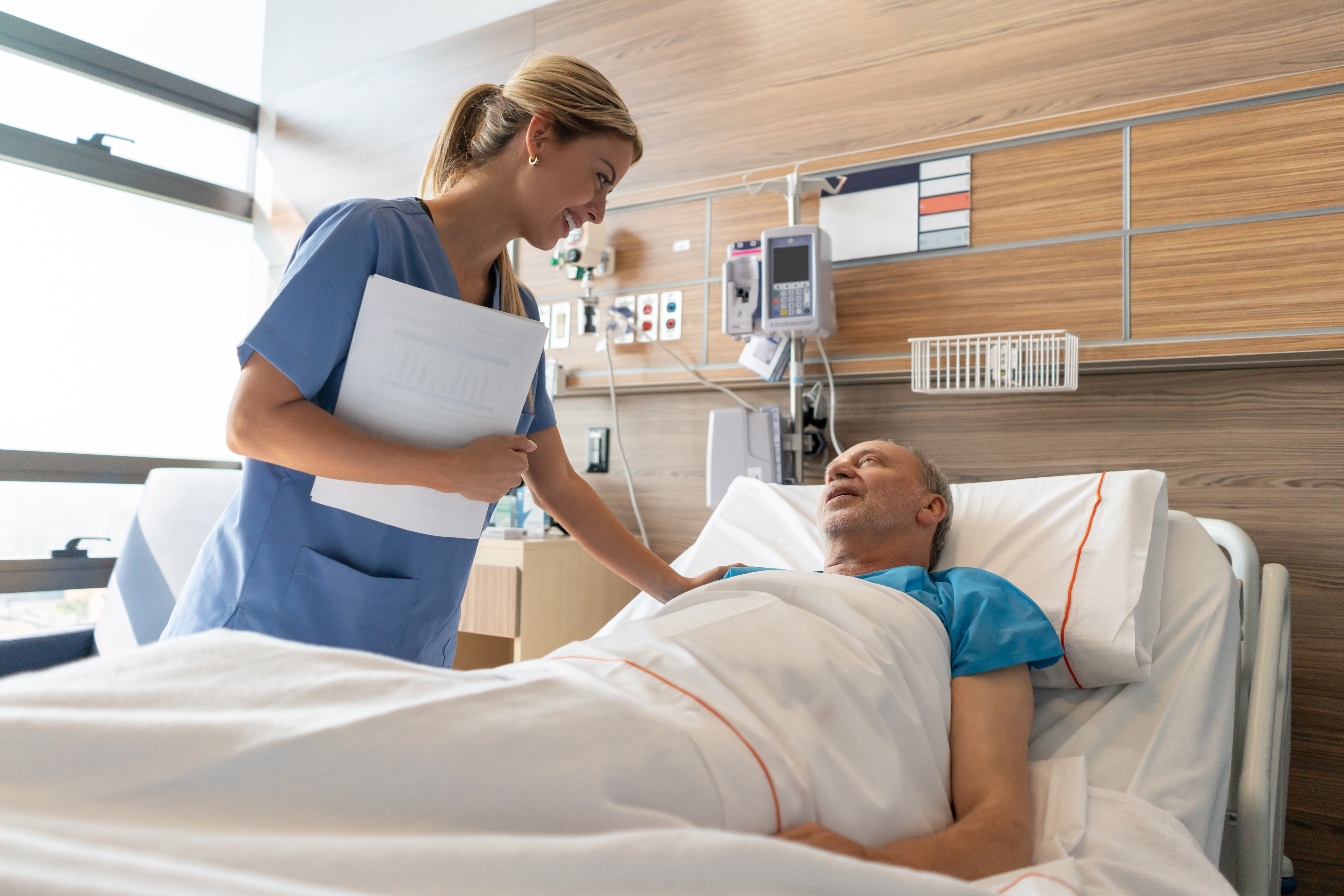 Nurse helping patient in bed